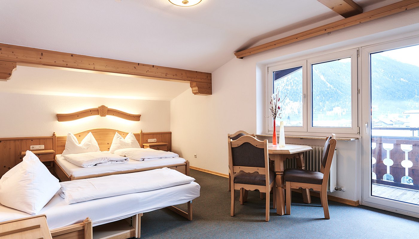 Spacious room with double bed, pull-out bed and seating area near window front