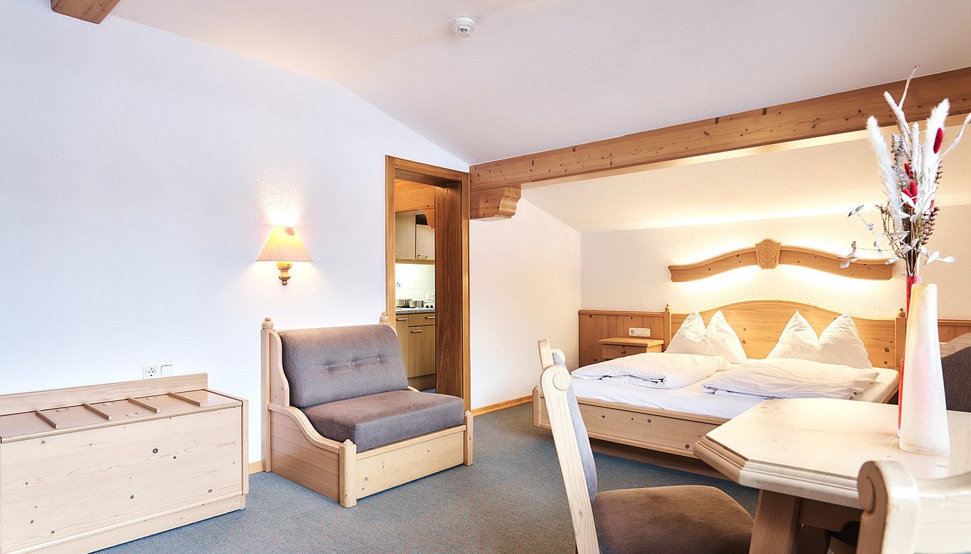 Cozy living-bedroom with dining table, double bed and kitchen access