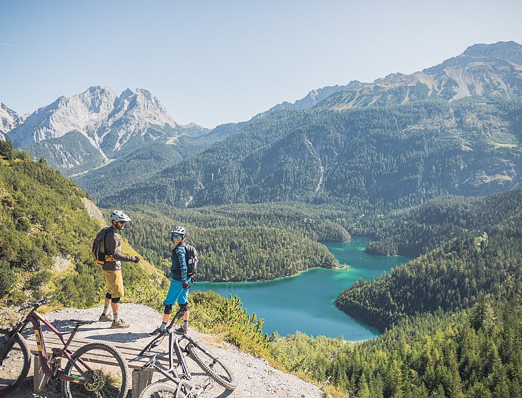 Mountain bikers enjoy the Alpine panorama and the emerald green Plansee lake